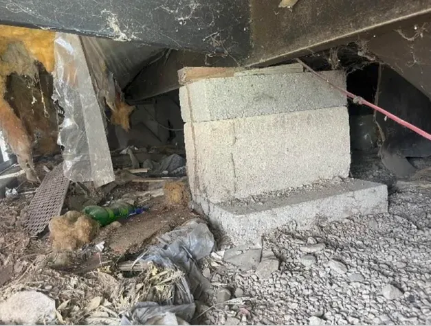 A close-up shot of a subterranean termite mud tube climbing up a stack of cinder blocks under a mobile home. Termite Control Barefoot Bay