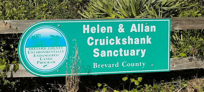 A green sign for the Helen & Allan Cruickshank Sanctuary, which is part of the Brevard County Environmentally Endangered Lands Program.