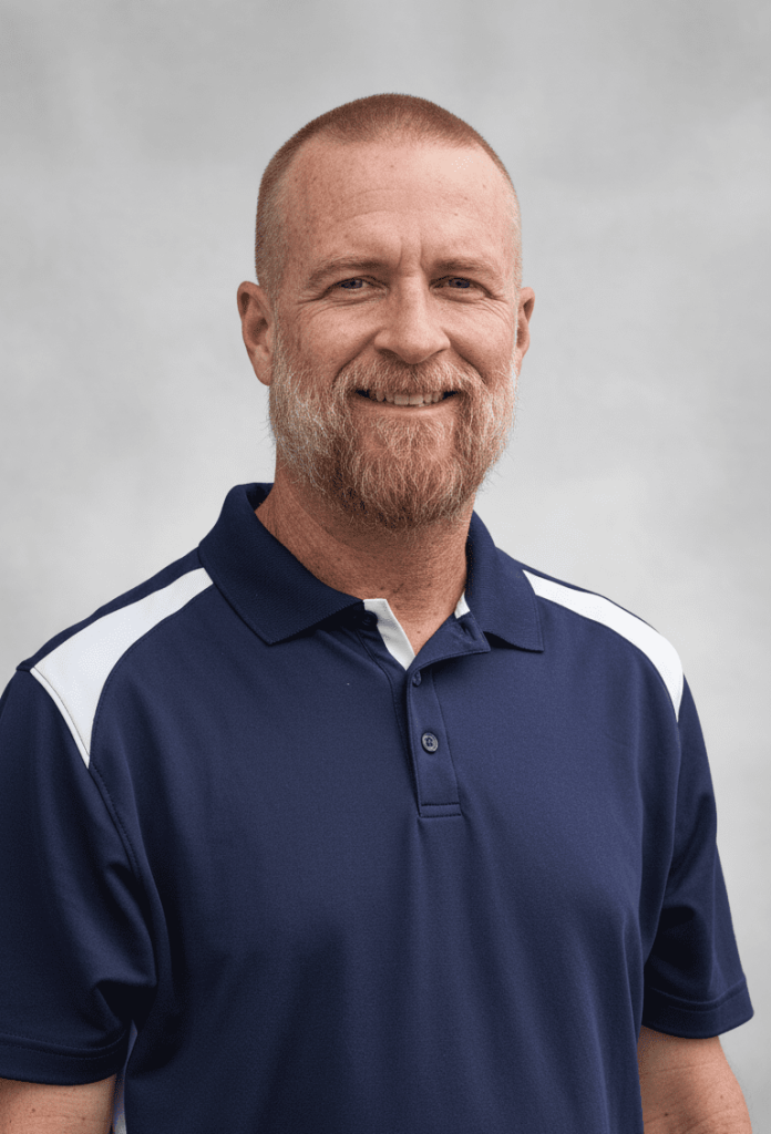 Professional headshot of a smiling pest control technician in a company polo shirt.